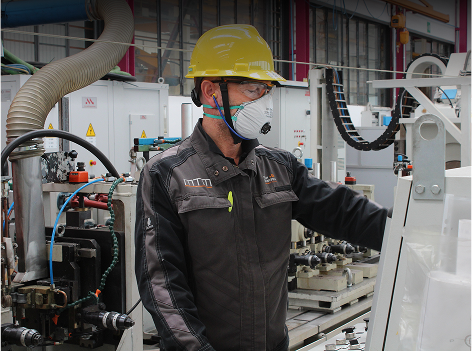 Person in mask working on machine